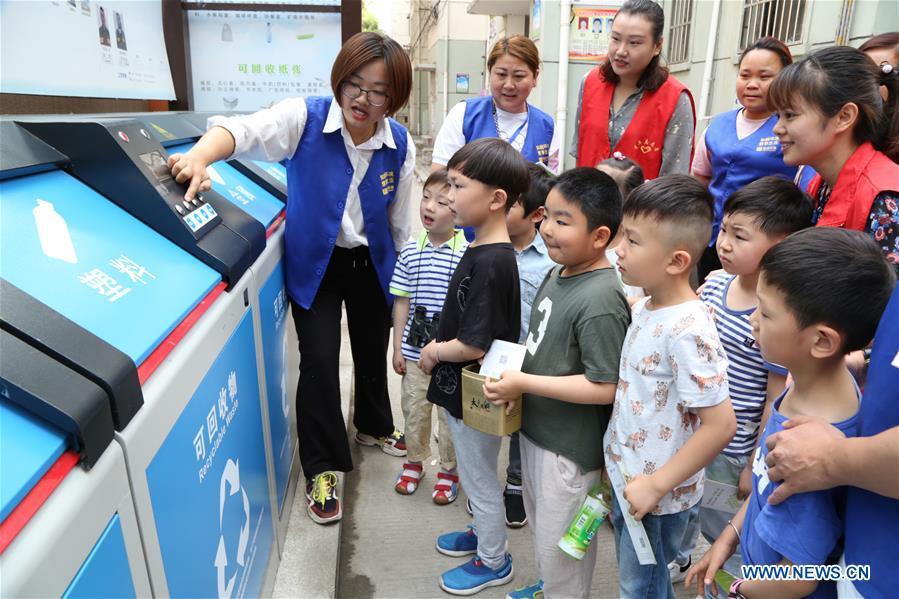 A volunteer illustrates the knowledge of garbage sorting to children in Hefei, east China\'s Anhui Province, June 4, 2019. Various activities are held across the country to raise people\'s awareness of garbage sorting and help them develop the habit of waste classification. (Xinhua/Fu Jun)