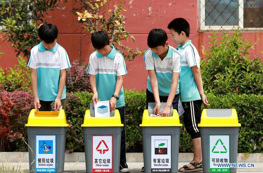 Students throw wastes into rubbish bins according to garbage sorting in Xingtai, north China\'s Hebei Province, June 4, 2019. Various activities were held across the country to raise people\'s awareness of garbage sorting and help them develop the habit of waste classification. (Xinhua/Song Jie)