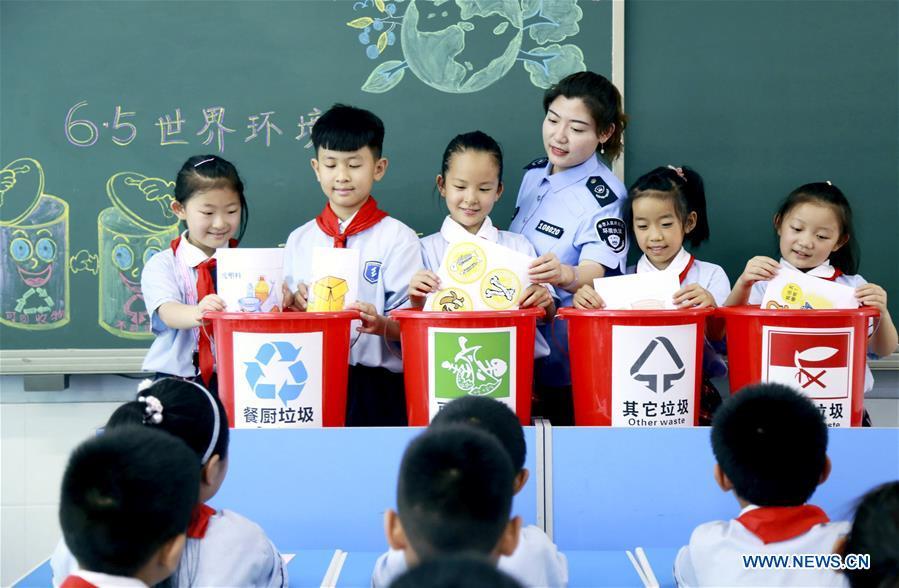 Pupils learn the knowledge of garbage sorting at an elementary school in Xingtai, north China\'s Hebei Province, June 4, 2019. Various activities are held across the country to raise people\'s awareness of garbage sorting and help them develop the habit of waste classification. (Xinhua/Zhang Chi)