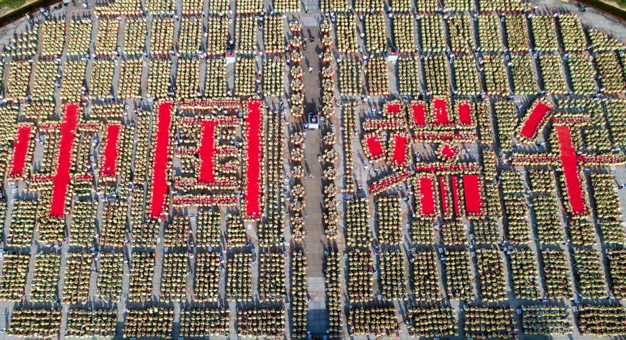 A bird\'s-eye view of the 9,478 people making zongzi, forming four Chinese characters that read \