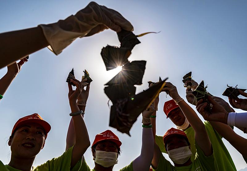 After setting a new mark recognized by Guinness World Records, people hold up their zongzi in Central China\'s Hubei Province, June 3, 2019.  (Photo Provided to chinadaily.com.cn)