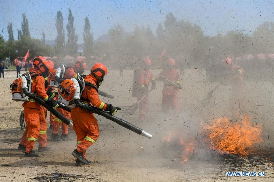 Newly-recruited firemen put out fire during a training in Hohhot, north China\'s Inner Mongolia Autonomous Region, June 5, 2019. Over 1,100 socially-recruited firemen are receiving a six-month training in Hohhot. (Xinhua/Peng Yuan)