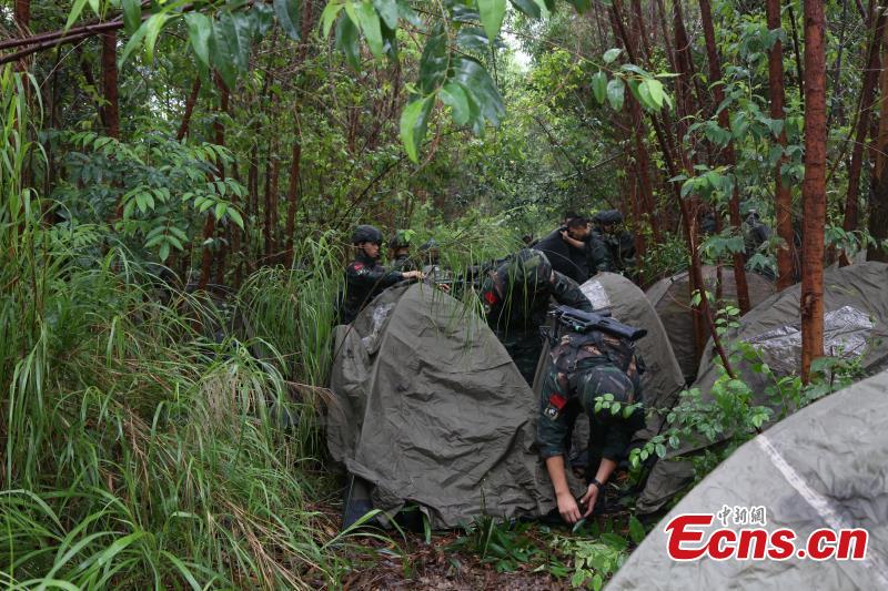 Armed police from the Snow Leopard Commando Unit undergoing intensive training in a hilly area under the blazing sun interrupted by a rainstorm. The training to last a week includes programs challenging the body and mind such as rescue missions and disposal of explosive ordnance. The Snow Leopard Commando Unit created in 2002 is mainly tasked with urban anti-terrorism missions and has safeguarded dozens of major events such as the Beijing Olympic Games, Xinhua reported. (Photo: China News Service/Li Jun)