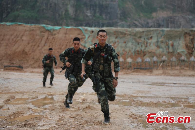 Armed police from the Snow Leopard Commando Unit undergoing intensive training in a hilly area under the blazing sun interrupted by a rainstorm. The training to last a week includes programs challenging the body and mind such as rescue missions and disposal of explosive ordnance. The Snow Leopard Commando Unit created in 2002 is mainly tasked with urban anti-terrorism missions and has safeguarded dozens of major events such as the Beijing Olympic Games, Xinhua reported. (Photo: China News Service/Li Jun)