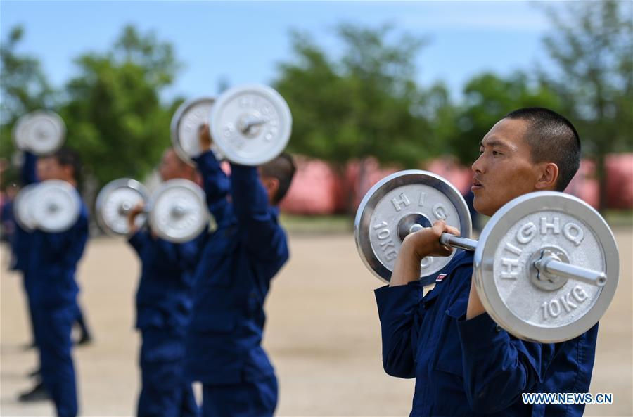 Newly-recruited firemen do physical exercises with barbells during a training in Hohhot, north China\'s Inner Mongolia Autonomous Region, June 5, 2019. Over 1,100 socially-recruited firemen are receiving a six-month training in Hohhot. (Xinhua/Peng Yuan)
