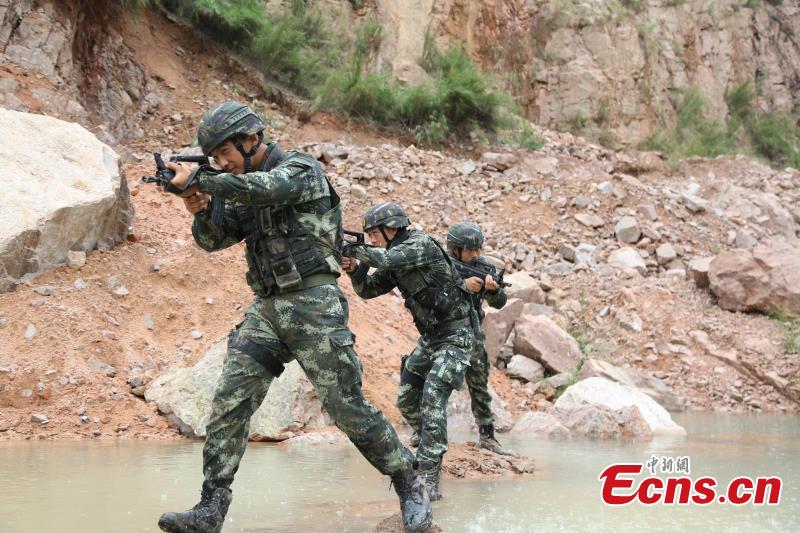 Armed police from the Snow Leopard Commando Unit undergoing intensive training in a hilly area under the blazing sun interrupted by a rainstorm. The training to last a week includes programs challenging the body and mind such as rescue missions and disposal of explosive ordnance. The Snow Leopard Commando Unit created in 2002 is mainly tasked with urban anti-terrorism missions and has safeguarded dozens of major events such as the Beijing Olympic Games, Xinhua reported. (Photo: China News Service/Li Jun)