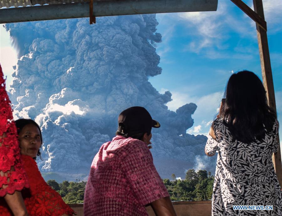 People watch the Mount Sinabung spewing thick ash in Karo, North Sumatra, Indonesia, June 9, 2019. A column of thick ash was spewed seven km high to the sky from the crater of Mount Sinabung volcano in Sumatra Island of western Indonesia on Sunday, the country\'s national volcanology agency said. (Xinhua/Anto Sembiring)