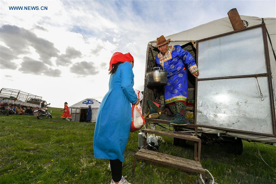 A family unload daily necessities from a truck during the nomadic migration on the Ar Horqin grassland in Chifeng City, north China\'s Inner Mongolia Autonomous Region, June 1, 2019. Yearly nomadic grazing is still a tradition for people live on the Ar Horqin grassland, where was listed of National Important Agricultural Heritage Systems in 2014. For a long time, herdsmen would decide the route and time of yearly nomadic grazing according to the growth of grassland. (Xinhua/Peng Yuan)