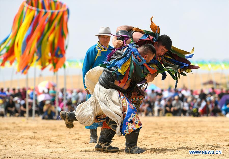 Participants take part in a wrestling contest during a desert Nadam Fair held in Naiman Banner, Tongliao City, north China\'s Inner Mongolia Autonomous Region, June 10, 2019. (Xinhua/Peng Yuan)