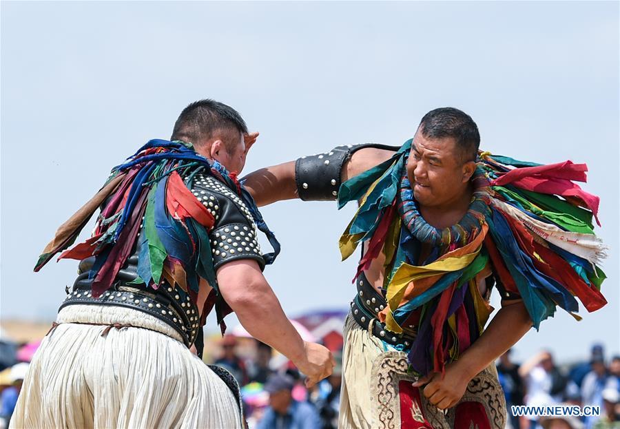 Participants take part in a wrestling contest during a desert Nadam Fair held in Naiman Banner, Tongliao City, north China\'s Inner Mongolia Autonomous Region, June 10, 2019. (Xinhua/Peng Yuan)