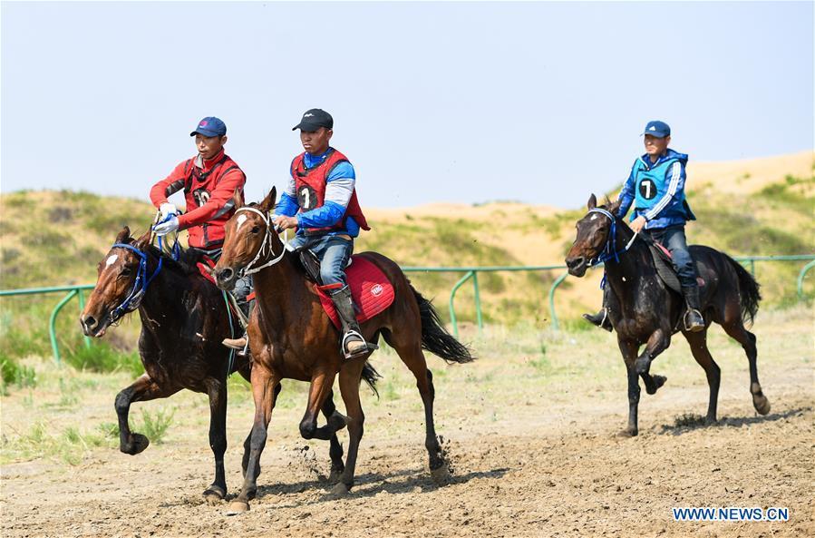 Participants take part in a horse riding contest during a desert Nadam Fair held in Naiman Banner, Tongliao City, north China\'s Inner Mongolia Autonomous Region, June 10, 2019. (Xinhua/Peng Yuan)
