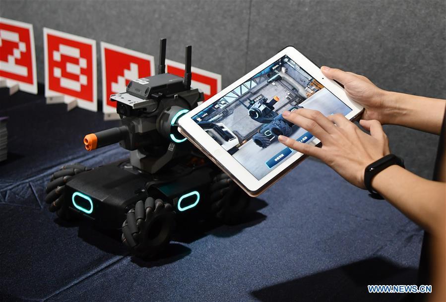 A staff member demonstrates an educational robot produced by Chinese drone maker DJI at an event in Beijing, capital of China, June 12, 2019. DJI launched its first educational robot RoboMaster S1 at an event on Wednesday. The robot, supporting 2 programming languages, features a configuration of 31 sensors and 46 programmable components. (Xinhua/Wang Qingqin)