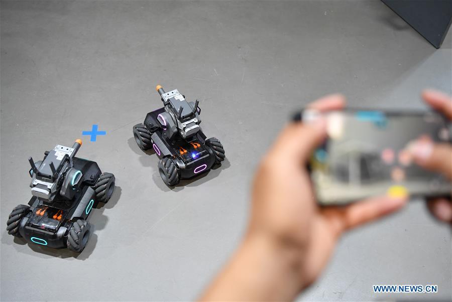 A staff member demonstrates educational robots produced by Chinese drone maker DJI at an event in Beijing, capital of China, June 12, 2019. DJI launched its first educational robot RoboMaster S1 at an event on Wednesday. The robot, supporting 2 programming languages, features a configuration of 31 sensors and 46 programmable components. (Xinhua/Wang Qingqin)