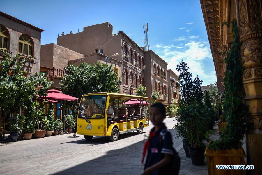 An electric-powered vehicle runs on a road in the ancient city of Kashgar, northwest China\'s Xinjiang Uygur Autonomous Region, June 12, 2019. The ancient city of Kashgar has been well prepared for the peak tourism season through multiple measures including improving infrastructure and service quality as well as staging acrobatics performances to help tourists better experience the time-honored folk culture here. (Xinhua/Zhao Ge)