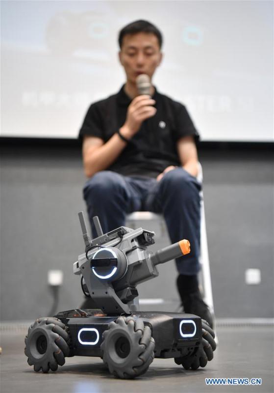 A staff member explains as an educational robot produced by Chinese drone maker DJI reacts at an event in Beijing, capital of China, June 12, 2019. DJI launched its first educational robot RoboMaster S1 at an event on Wednesday. The robot, supporting 2 programming languages, features a configuration of 31 sensors and 46 programmable components. (Xinhua/Wang Qingqin)