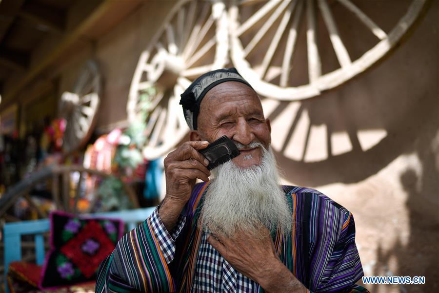 An elderly takes a rest in the ancient city of Kashgar, northwest China\'s Xinjiang Uygur Autonomous Region, June 12, 2019. The ancient city of Kashgar has been well prepared for the peak tourism season through multiple measures including improving infrastructure and service quality as well as staging acrobatics performances to help tourists better experience the time-honored folk culture here. (Xinhua/Zhao Ge)