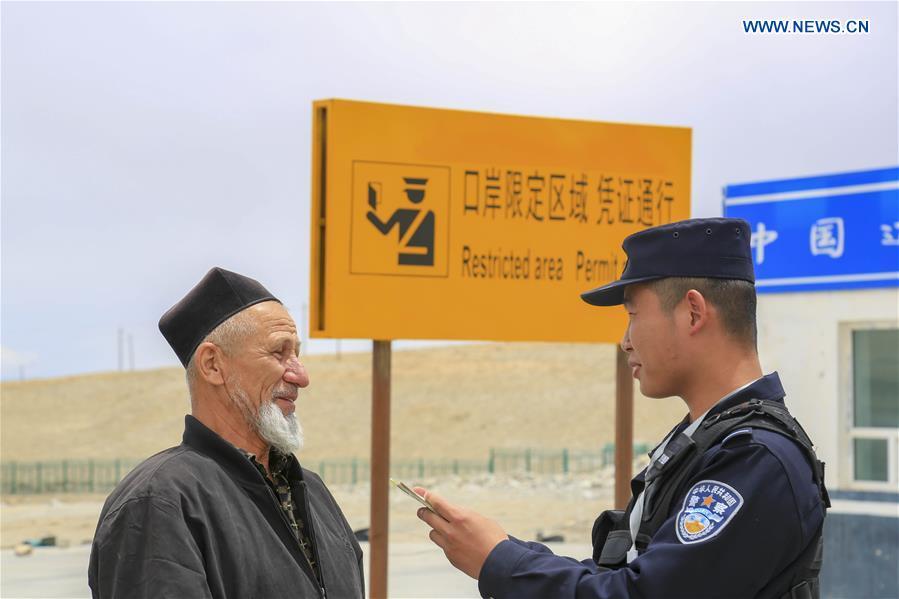 A Chinese border policeman checks information of a man from Tajikistan at the Karasu port in Tajik Autonomous County of Taxkorgan, northwest China\'s Xinjiang Uygur Autonomous Region, on June 11, 2019. With the Belt and Road Initiative, trade between China and Tajikistan has continued to develop. The Karasu port between the two countries has seen large quantities of goods cleared by customs every year. (Xinhua/Huang Huan)