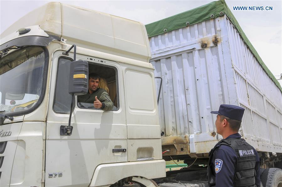 A driver from Tajikistan gestures to a Chinese border policeman at the Karasu port in Tajik Autonomous County of Taxkorgan, northwest China\'s Xinjiang Uygur Autonomous Region, on June 11, 2019. With the Belt and Road Initiative, trade between China and Tajikistan has continued to develop. The Karasu port between the two countries has seen large quantities of goods cleared by customs every year. (Xinhua/Huang Huan)