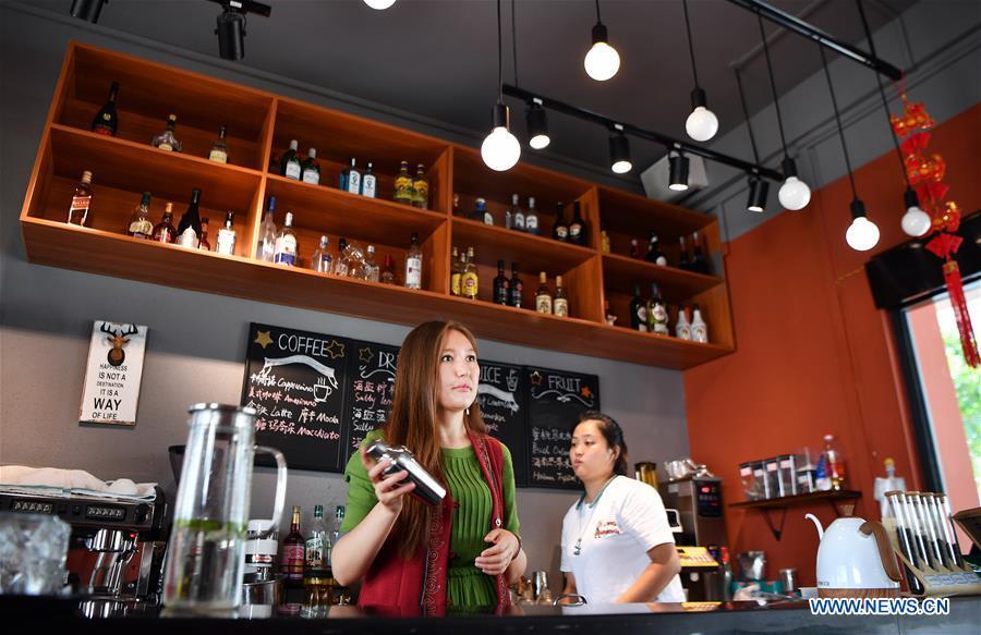 Takyrbasheva Asel (L), a student from Kyrgyzstan, works at a coffee shop during her spare time in Hainan University in Haikou, south China\'s Hainan Province, June 13, 2019. Kyrgyz girl Takyrbasheva Asel majors in Tourism Management in Hainan University. She has dedicated herself in experiencing the Chinese culture, including the learning of traditional Chinese musical instruments, Taiji and martial arts, and tea art since she came to China three years ago. She hoped she could stay in China after graducation and invite people from her hometown to come and experience the Chinese culture. Statistics showed that over 4,600 Kyrgyz students studied in China in 2018. (Xinhua/Guo Cheng)
