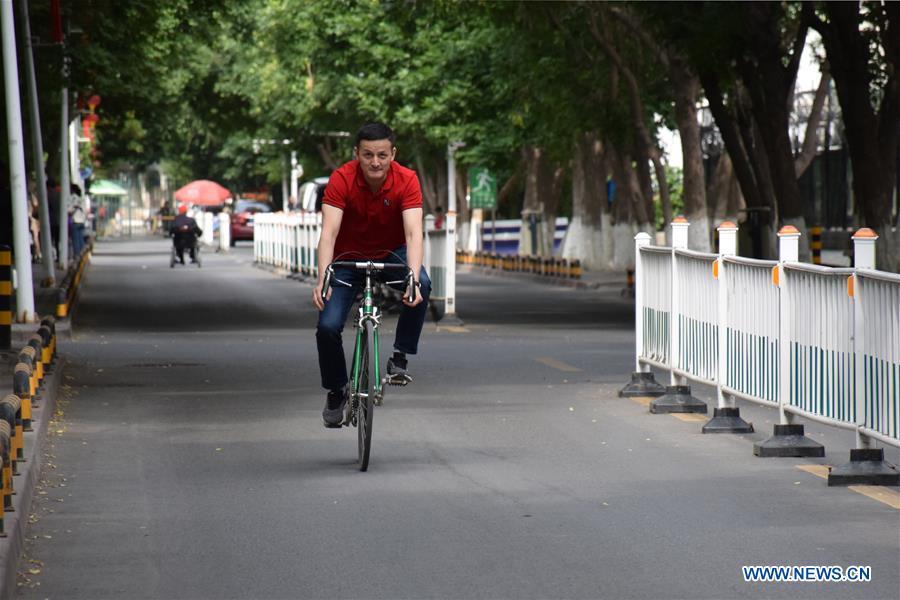 Sadyrbek, a Kyrgyz PhD candidate studying in China, goes by bike to the office of Xinjiang Institute of Ecology and Geography of Chinese Academy of Sciences in Urumqi, northwest China\'s Xinjiang Uygur Autonomous Region, June 11, 2019. (Xinhua/Bai Jiali)
