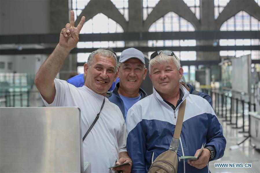 Drivers from Kazakhstan pose for photos as they prepare to leave Horgos, northwest China\'s Xinjiang Uygur Autonomous Region, June 12, 2019. With the Belt and Road Initiative, the trade between Xinjiang, Kyrgyzstan and Tajikistan has continued to develop. On the southern border of Xinjiang, three ports, Turugart, Erkeshtam and Karasu, between China and Kyrgyzstan and Tajikistan, saw large quantities of goods cleared by customs every year. (Xinhua/Zhou Xu)