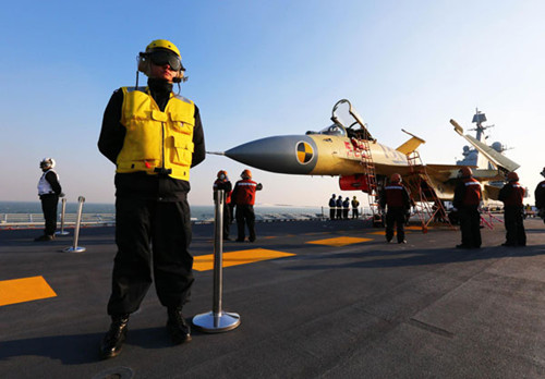 Staff members check a carrier-borne J-15 fighter jet on China's first aircraft carrier, the Liaoning. [Undated photo/Xinhua]