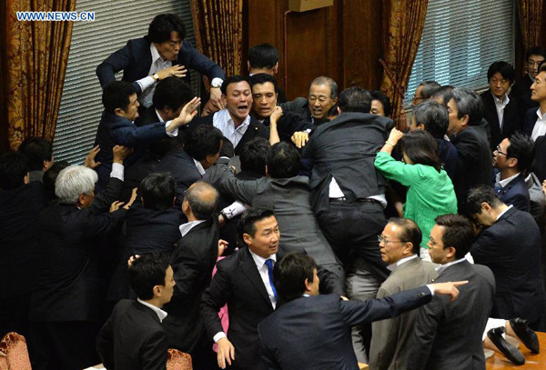 Japanese ruling and opposition lawmakers scuffle at the chamber in Tokyo, Japan, Sept. 17, 2015. A special committee under the upper house of the Japanese national Diet passed the controversial government-backed security-related bills amid chaos in the chamber. (Photo: Xinhua/Ma Ping) Japanese ruling and opposition lawmakers scuffle at the chamber in Tokyo, Japan, Sept. 17, 2015. A special committee under the upper house of the Japanese national Diet passed the controversial government-backed security-related bills amid chaos in the chamber. (Photo: Xinhua/Ma Ping)