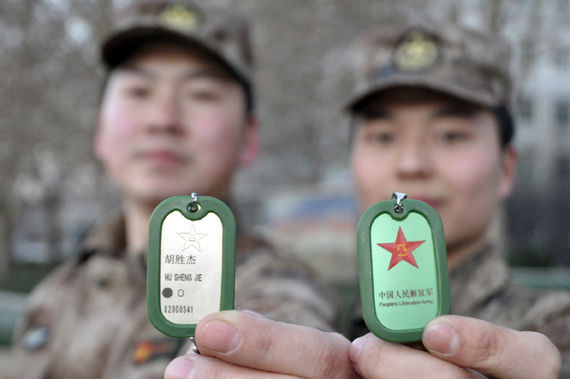 Two PLA servicemen show their new personal identification tags. (Photo/China.com) Two PLA servicemen show their new personal identification tags. (Photo/China.com)