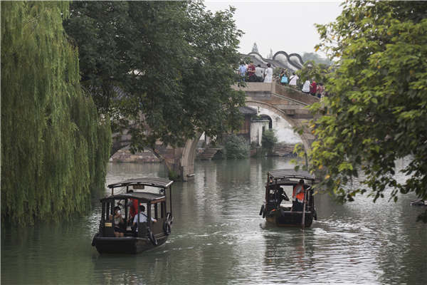 Crisscrossing waterways are now the biggest draw for visitors to Wuzhen, Zhejiang province. Visitors stroll along the banks or hop aboard boats to take in the views. (Photo by Shi Kuihua/For China Daily) Crisscrossing waterways are now the biggest draw for visitors to Wuzhen, Zhejiang province. Visitors stroll along the banks or hop aboard boats to take in the views. (Photo by Shi Kuihua/For China Daily)
