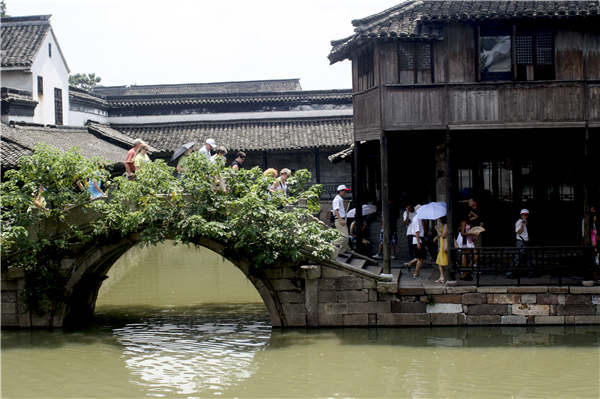 Traditional houses, featuring gray rooftops and white walls, flank the riversides. (Photo provided to China Daily) Traditional houses, featuring gray rooftops and white walls, flank the riversides. (Photo provided to China Daily)