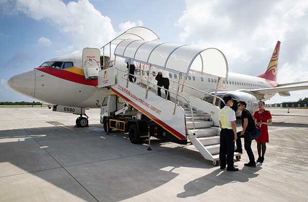 Passengers board a flight at an airport on Yongxing Island. The first regular civil charter flight between Haikou, capital of Hainan province, and the island was operated on Thursday.Song Guoqiang / For China Daily Passengers board a flight at an airport on Yongxing Island. The first regular civil charter flight between Haikou, capital of Hainan province, and the island was operated on Thursday.Song Guoqiang / For China Daily