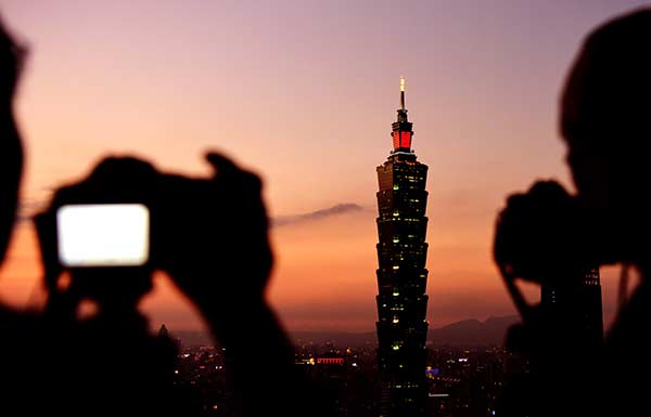 People take photos of the landmark Taipei 101 building in Taiwan in January. (Photo/Xinhua) People take photos of the landmark Taipei 101 building in Taiwan in January. (Photo/Xinhua)