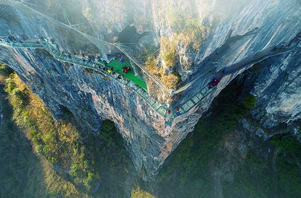 Passes built on the cliffs and a glass suspension bridge are among the highlights of Zhusha ancient town in Guizhou, which has turned from mercury mine site to a tourist hot spot. (Photo provided to China Daily) Passes built on the cliffs and a glass suspension bridge are among the highlights of Zhusha ancient town in Guizhou, which has turned from mercury mine site to a tourist hot spot. (Photo provided to China Daily)