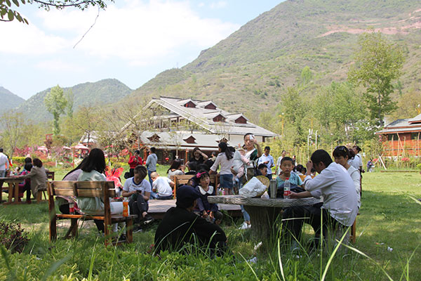 Tourists relax in a meadow in Huaqiao village in Kangxian county, Gansu province.(Photo provided to China Daily) Tourists relax in a meadow in Huaqiao village in Kangxian county, Gansu province.(Photo provided to China Daily)