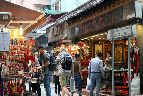 Visitors buy souvenirs at a street market. (Photo by Li Peng/Xinhua) Visitors buy souvenirs at a street market. (Photo by Li Peng/Xinhua)