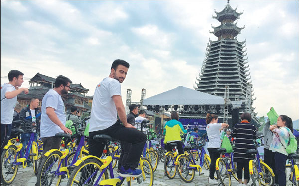 Foreign tourists ride shared bikes to China's first ethnic-themed outdoor festival held in Rongjiang, Guizhou province, earlier this year. The festival involves a combination of sports and tourism with characteristics of Dong and Miao ethnic groups.Deng Gang/For China Daily Foreign tourists ride shared bikes to China's first ethnic-themed outdoor festival held in Rongjiang, Guizhou province, earlier this year. The festival involves a combination of sports and tourism with characteristics of Dong and Miao ethnic groups.Deng Gang/For China Daily