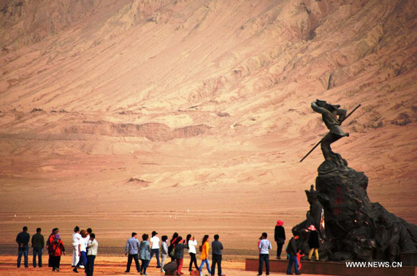 Tourists pose for photos next to a statue of Monkey King, a character of the 16th-century Chinese novel Journey to the West, in the Flaming Mountains Scenic Area in Turpan, Northwest China's Xinjiang Uygur autonomous region, April 6, 2014.(Photo/Xinhua) Tourists pose for photos next to a statue of Monkey King, a character of the 16th-century Chinese novel Journey to the West, in the Flaming Mountains Scenic Area in Turpan, Northwest China's Xinjiang Uygur autonomous region, April 6, 2014.(Photo/Xinhua)