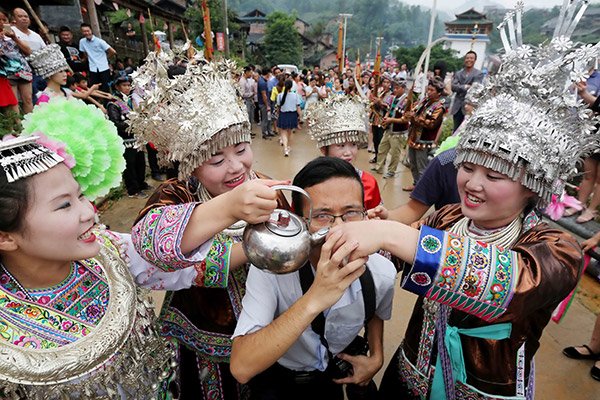 A tourist participates in a local Miao ethnic tradition in Liuzhou, Guangxi Zhuang autonomous region. (Tan Kaixing/for China Daily) A tourist participates in a local Miao ethnic tradition in Liuzhou, Guangxi Zhuang autonomous region. (Tan Kaixing/for China Daily)