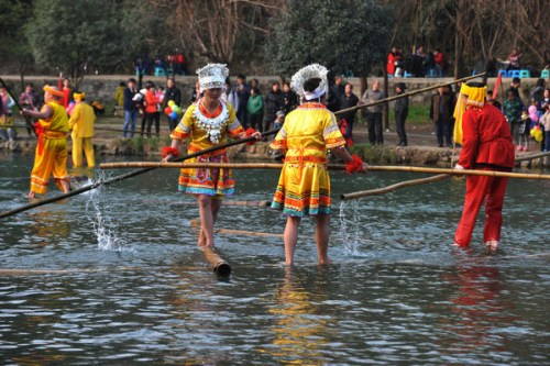 Some members of the Miao ethnic group in Guiyang, Guizhou province, perform bamboo drifting during a festival. (Photo provided to China Daily)