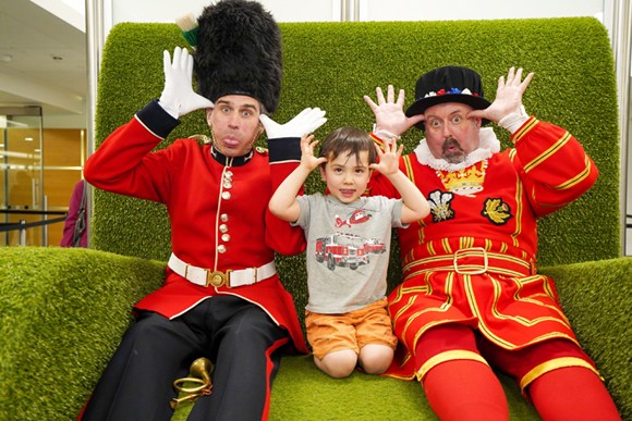 A child poses for a photo with welcomers at Londons Heathrow Airport, May 8.  (Photo provided to chinadaily.com.cn)