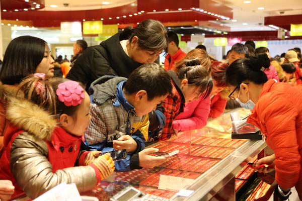 Potential buyers examine gold items at a jewelry store in Xuchang, Henan province. China's consumption growth is likely to witness a slowdown in 2015.(Provided to China Daily) Potential buyers examine gold items at a jewelry store in Xuchang, Henan province. China's consumption growth is likely to witness a slowdown in 2015.(Provided to China Daily)