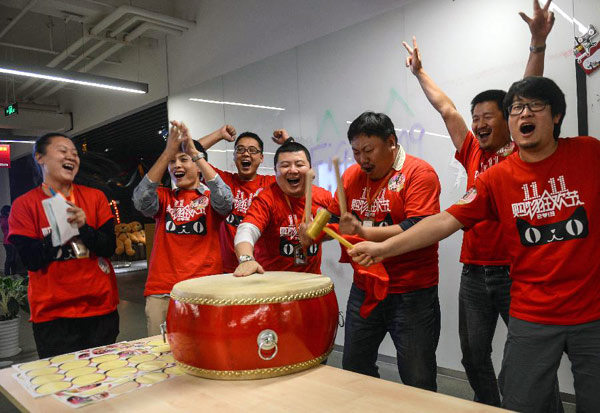 Staff members of Tmall, a business-to-consumer marketplace of China's biggest e-commerce platform Alibaba, cheer for rising order volumes in Hangzhou, capital of East China's Zhejiang province, Nov. 11, 2013. (Photo/Xinhua)