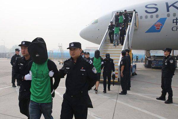 Telecom fraud suspectes are escorted off a plane by Chinese police from Kenya. (Photo/Xinhua) Telecom fraud suspectes are escorted off a plane by Chinese police from Kenya. (Photo/Xinhua)