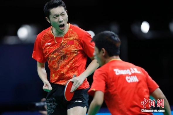 Zhang Jike and Xu Xin of China celebrate after winning Maharu Yoshimura and Niwa Koki of Japan during the men's team gold medal match of table tennis at the 2016 Rio Olympic Games in Rio de Janeiro, Brazil, Aug. 15, 2016. (Photo: China News Service/Sheng Jiapeng) Zhang Jike and Xu Xin of China celebrate after winning Maharu Yoshimura and Niwa Koki of Japan during the men's team gold medal match of table tennis at the 2016 Rio Olympic Games in Rio de Janeiro, Brazil, Aug. 15, 2016. (Photo: China News Service/Sheng Jiapeng)