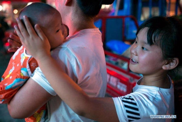 The nine-year-old Zhang Sichen (R) interacts with her three-month-old sister Zhang Yuchen in Qianshuiwan Community of Shushan District in Hefei, East China's Anhui province, July 27, 2016.(Photo/Xinhua) The nine-year-old Zhang Sichen (R) interacts with her three-month-old sister Zhang Yuchen in Qianshuiwan Community of Shushan District in Hefei, East China's Anhui province, July 27, 2016.(Photo/Xinhua)