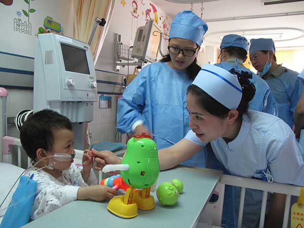A nurse talks with a child of the Qiong ethnic group, who just had a surgical operation for congenital heart disease, at the Chengdu Military General Hospital.(Photo by Huang Zhiling/China Daily) A nurse talks with a child of the Qiong ethnic group, who just had a surgical operation for congenital heart disease, at the Chengdu Military General Hospital.(Photo by Huang Zhiling/China Daily)