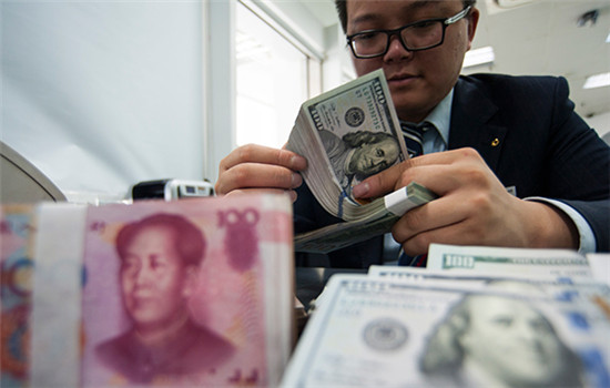 An employee at a bank counter in Nantong, Jiangsu province, counts renminbi and dollars. (Photo/China Daily) An employee at a bank counter in Nantong, Jiangsu province, counts renminbi and dollars. (Photo/China Daily)