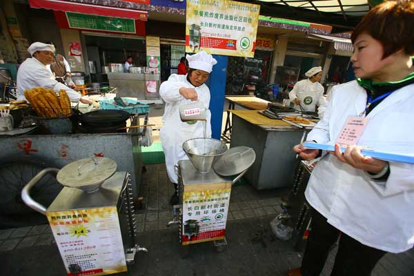 A community worker (center) in Shanghai recycles used cooking oil on March 6. Public concern over illegal oil pushed Chinese scientists to find ways to fight against gutter oil. Wu Kai / for China Daily A community worker (center) in Shanghai recycles used cooking oil on March 6. Public concern over illegal oil pushed Chinese scientists to find ways to fight against gutter oil. Wu Kai / for China Daily