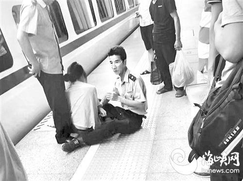 A member of staff at a railway station held back a female passenger who suddenly rushed toward the edge of the platform with the aim of jumping in front of the train. (Photo/hxnews.com) A member of staff at a railway station held back a female passenger who suddenly rushed toward the edge of the platform with the aim of jumping in front of the train. (Photo/hxnews.com)