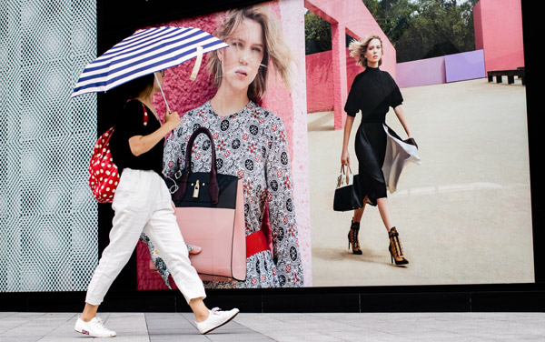 A woman walks past a Louis Vuitton advertisement in Fuzhou, capital of East China's Fujian province. (Photo by Chen Hao/For China Daily) A woman walks past a Louis Vuitton advertisement in Fuzhou, capital of East China's Fujian province. (Photo by Chen Hao/For China Daily)